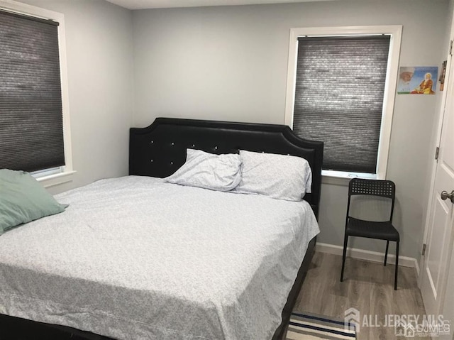 bedroom featuring wood finished floors and baseboards