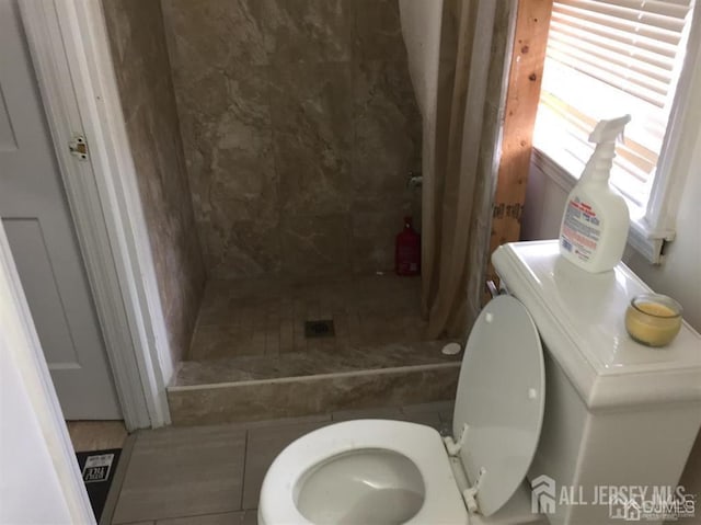 full bathroom with washer / clothes dryer, a shower stall, and toilet