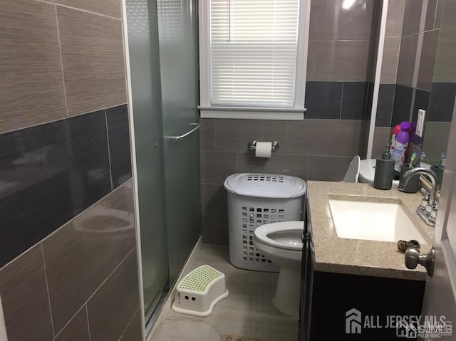 full bathroom with tile patterned flooring, toilet, vanity, tile walls, and a stall shower