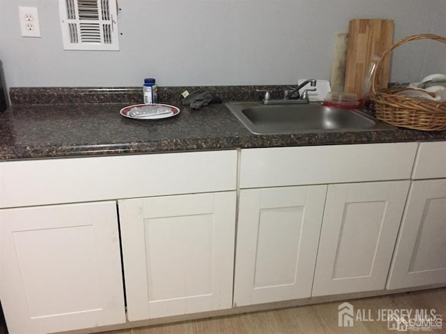 details with visible vents, a sink, and wood finished floors