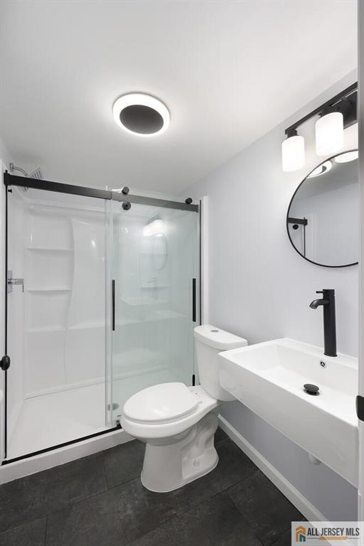 bathroom with tile patterned flooring, a shower stall, and toilet