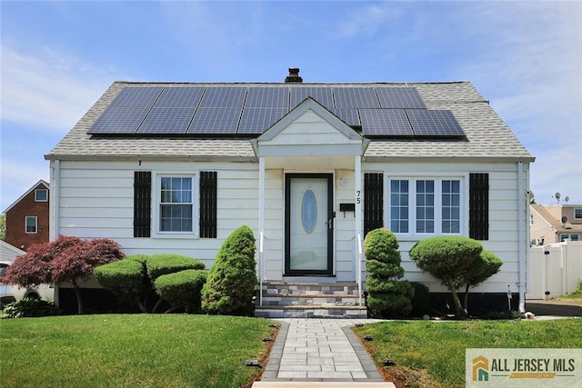 bungalow with entry steps, solar panels, and a front yard