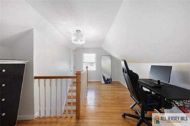 office with vaulted ceiling, light wood-style flooring, and baseboards
