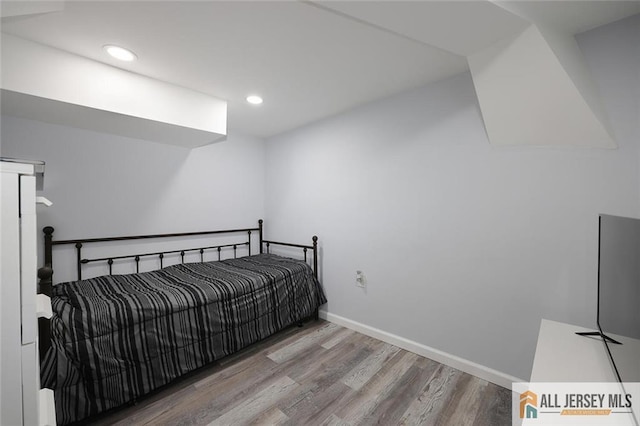 bedroom featuring wood finished floors, baseboards, and recessed lighting