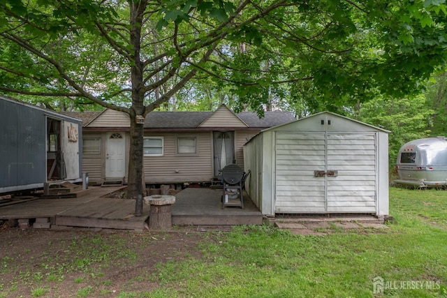 144 E Greystone Rd Unit 146, Old Bridge, NJ 08857 - back of property with roof with shingles, a storage shed, an outbuilding, a lawn, and a deck
