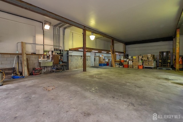 144 E Greystone Rd Unit 146, Old Bridge, NJ 08857 - garage with electric panel, concrete block wall, and a workshop area