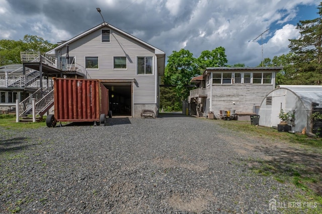 144 E Greystone Rd Unit 146, Old Bridge, NJ 08857 - back of property featuring stairway, gravel driveway, a deck, and an attached garage