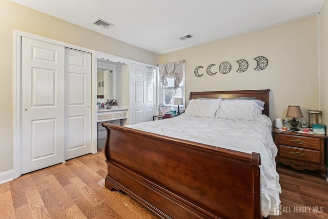 bedroom featuring light wood-style floors and visible vents