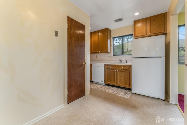 4420 Birchwood Ct, North Brunswick, NJ 08902 - kitchen with white appliances, brown cabinetry, light countertops, and decorative backsplash