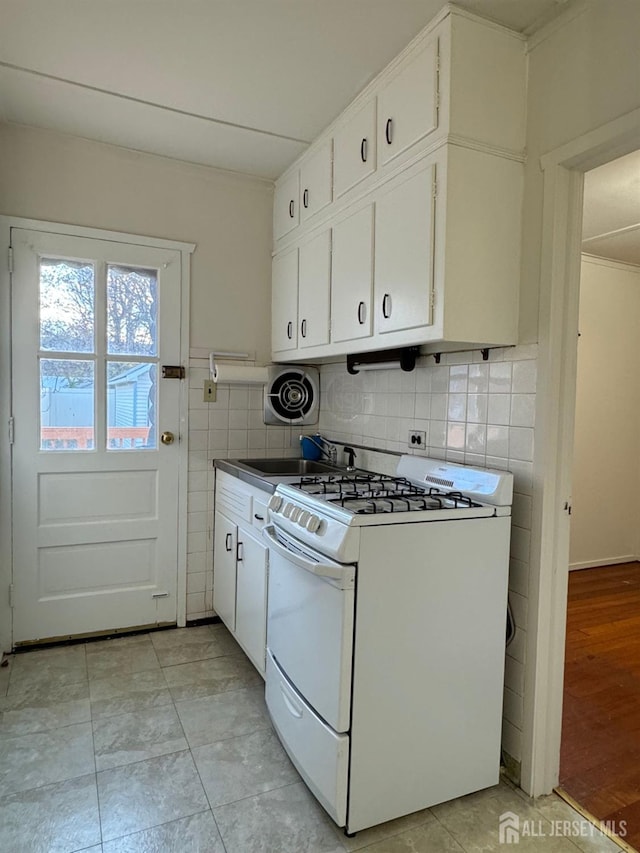 kitchen featuring visible vents, white cabinetry, gas range gas stove, and tile walls