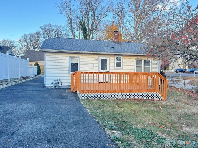 rear view of house featuring a yard and a wooden deck