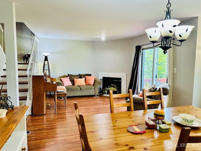 91 Heather Ct, South Brunswick, NJ 08852 - dining space with a tile fireplace, wood finished floors, a chandelier, and stairway