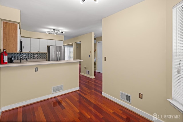 204 Concord Pl, North Brunswick, NJ 08902 - kitchen with appliances with stainless steel finishes, a peninsula, dark wood-type flooring, light countertops, and decorative backsplash