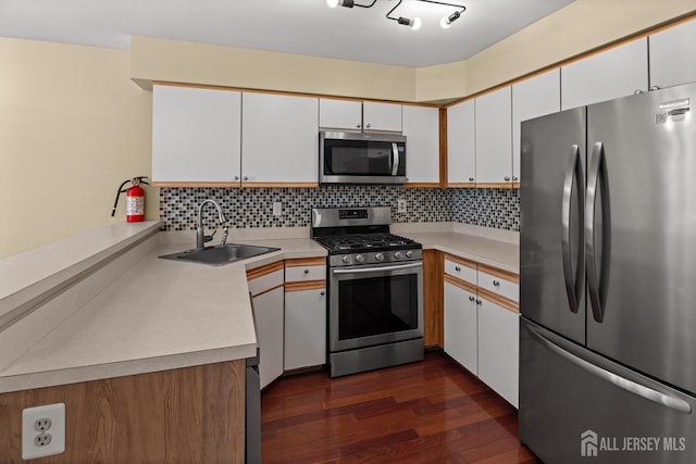 204 Concord Pl, North Brunswick, NJ 08902 - kitchen featuring stainless steel appliances, dark wood-style floors, tasteful backsplash, light countertops, and a peninsula
