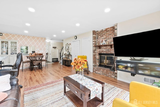 372 Mcdowell Dr, East Brunswick, NJ 08816 - living room featuring wood finished floors, a brick fireplace, recessed lighting, and an accent wall