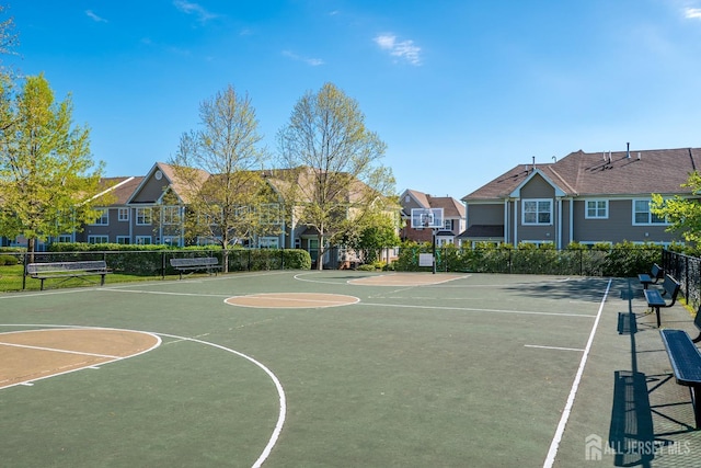 view of sport court featuring fence, community basketball court, and a residential view