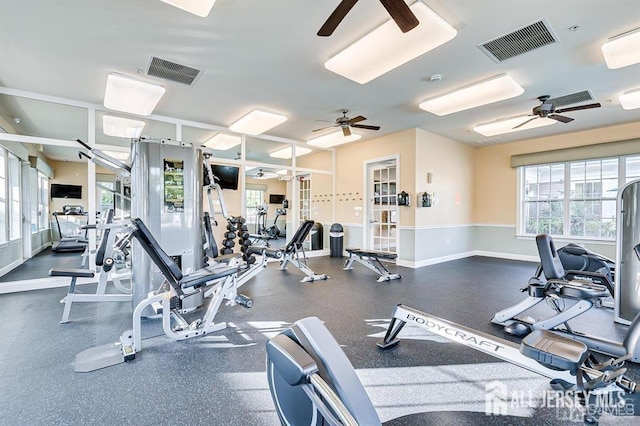 gym with ceiling fan, visible vents, and baseboards
