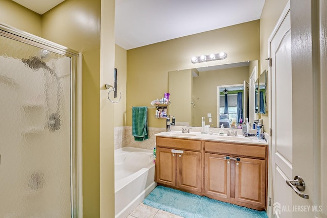 bathroom featuring tile patterned flooring, a sink, a garden tub, and a shower stall