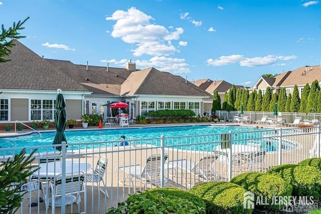 pool with a patio and fence