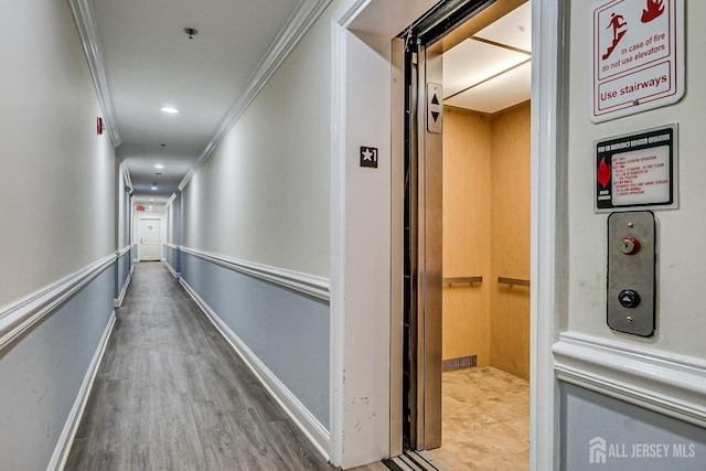 corridor featuring crown molding, elevator, and wood finished floors