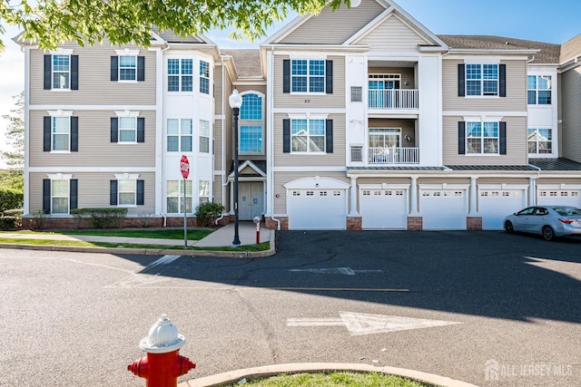 multi unit property featuring a garage and driveway