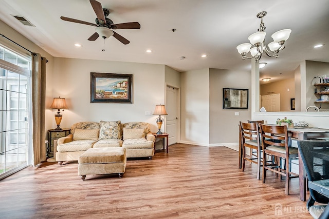 living area featuring recessed lighting, visible vents, light wood-style flooring, and ceiling fan with notable chandelier