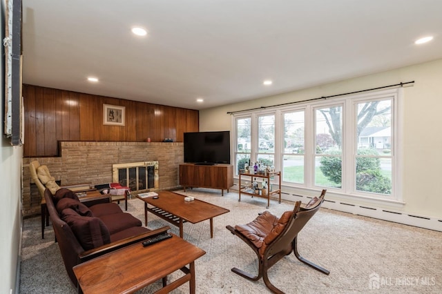 living room with recessed lighting, light carpet, a fireplace, and wood walls