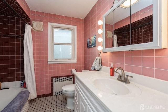 full bathroom featuring radiator heating unit, tile walls, toilet, vanity, and shower / bath combo