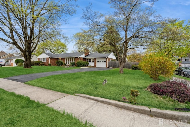 ranch-style house with asphalt driveway, a garage, a chimney, and brick siding