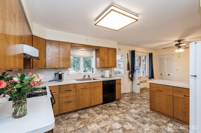 kitchen featuring dishwasher, a sink, brown cabinetry, and light countertops