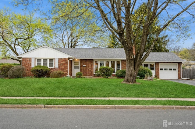 ranch-style home with an attached garage, asphalt driveway, a front lawn, and brick siding