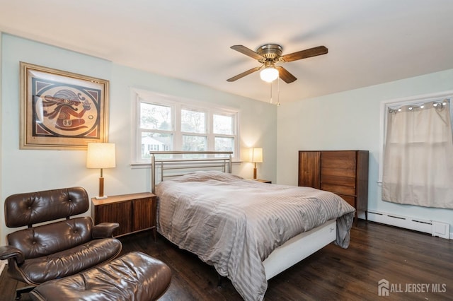bedroom with dark wood-style floors, a baseboard heating unit, and a ceiling fan