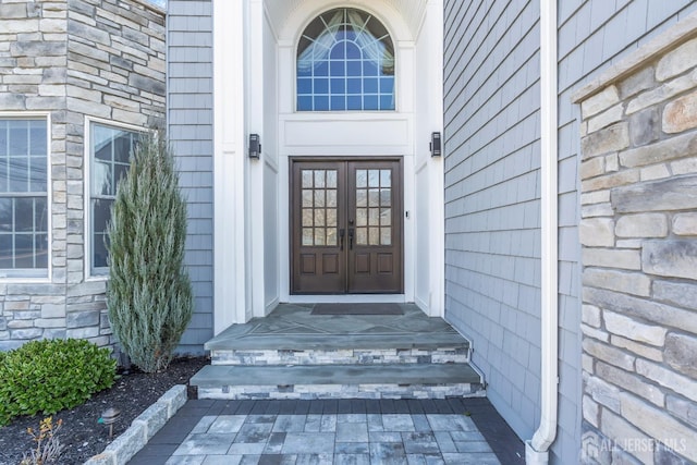 doorway to property with stone siding and french doors