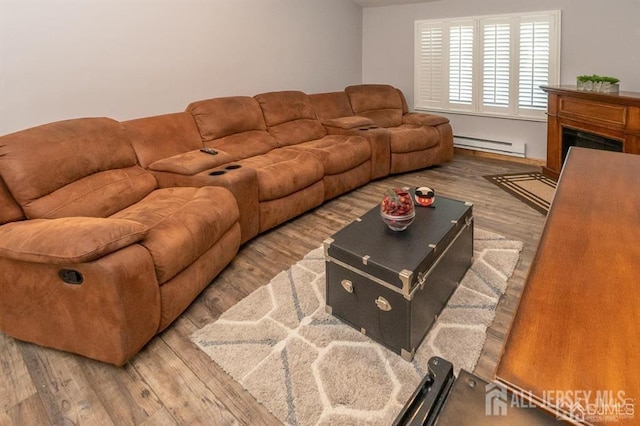 living area with baseboard heating, wood finished floors, and a fireplace
