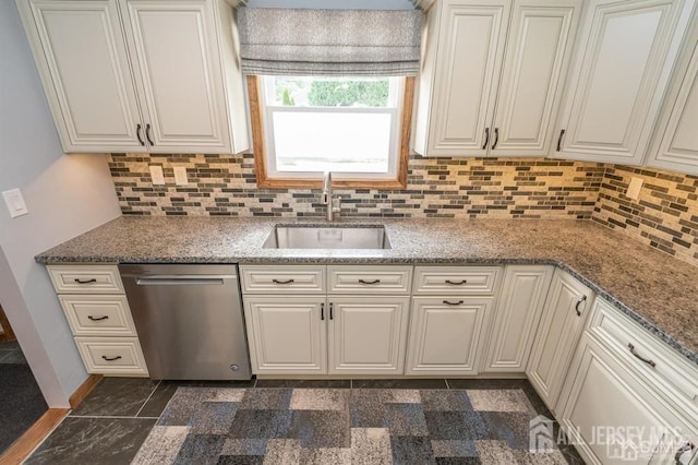 kitchen featuring stainless steel dishwasher, a sink, backsplash, white cabinetry, and light stone counters