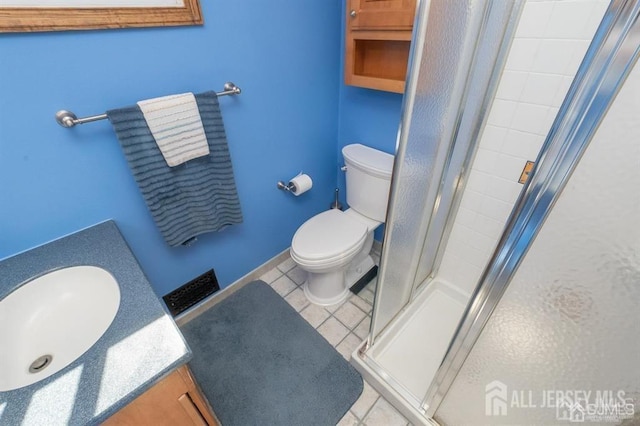 full bathroom featuring a stall shower, toilet, vanity, and tile patterned floors