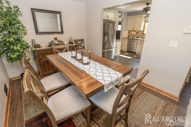 dining space featuring ceiling fan, baseboards, and dark wood-type flooring