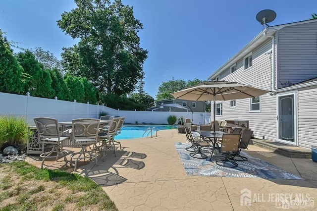 view of swimming pool with outdoor dining area, a fenced backyard, and a patio area