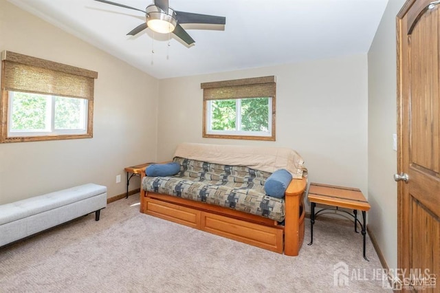 bedroom with multiple windows, light colored carpet, lofted ceiling, baseboards, and a ceiling fan