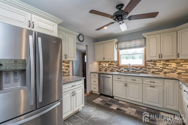 kitchen with appliances with stainless steel finishes, a sink, a ceiling fan, and decorative backsplash