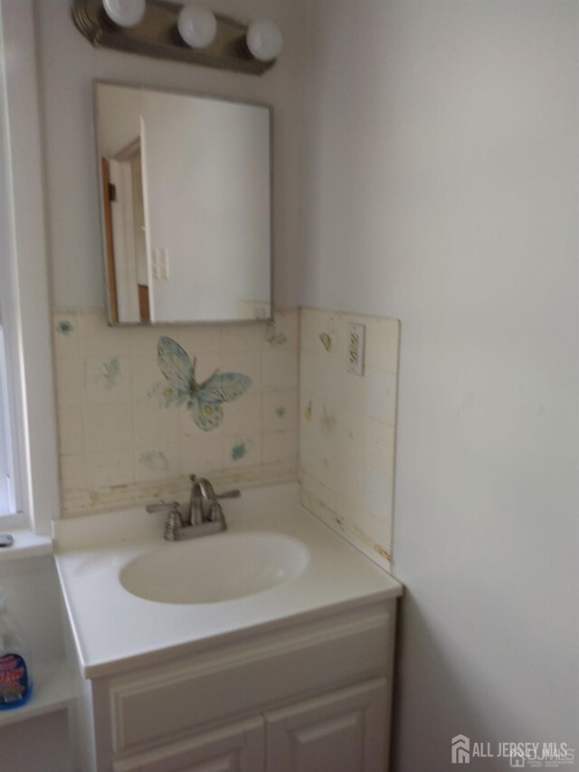 bathroom with vanity and decorative backsplash