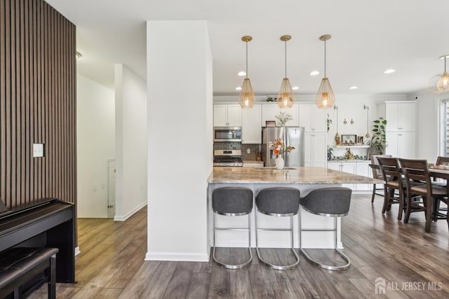 106 Ellsworth Way S, Brunswick, NJ 08852 - kitchen with appliances with stainless steel finishes, a kitchen bar, light stone countertops, dark wood-style flooring, and white cabinetry