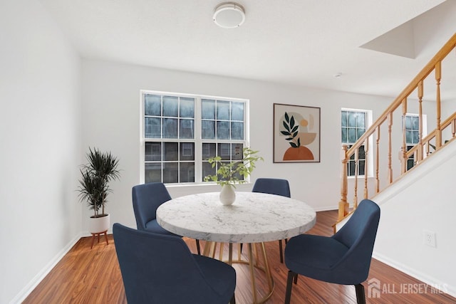 dining area featuring stairway, baseboards, and wood finished floors