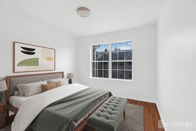 bedroom with baseboards and wood finished floors