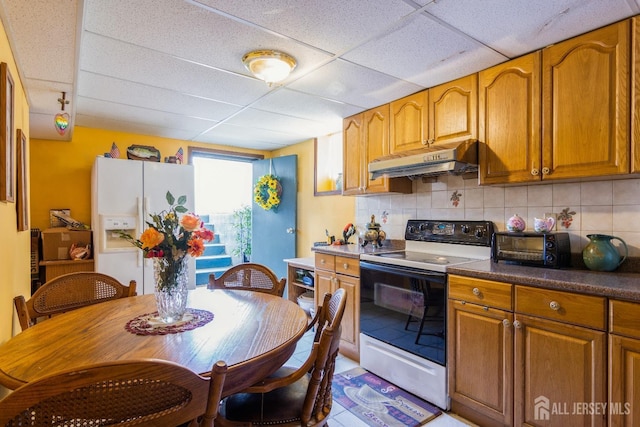 99 William St, South River, NJ 08882 - kitchen with range with electric stovetop, under cabinet range hood, a drop ceiling, white refrigerator with ice dispenser, and brown cabinets