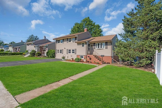 73 Webb Dr, Fords, NJ 08863 - split level home featuring asphalt driveway, a front lawn, and a chimney