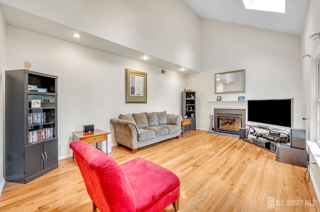 10 Rauer Ct, South Plainfield, NJ 07080 - living room with a glass covered fireplace, light wood finished floors, a skylight, high vaulted ceiling, and recessed lighting