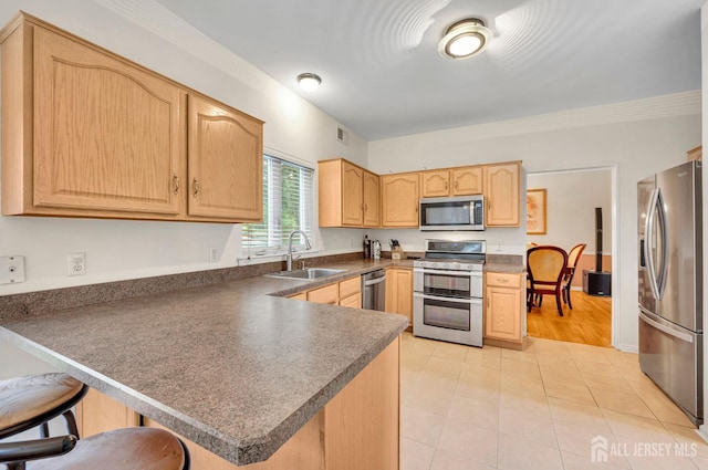 10 Rauer Ct, South Plainfield, NJ 07080 - kitchen featuring appliances with stainless steel finishes, light brown cabinets, a peninsula, light tile patterned floors, and dark countertops