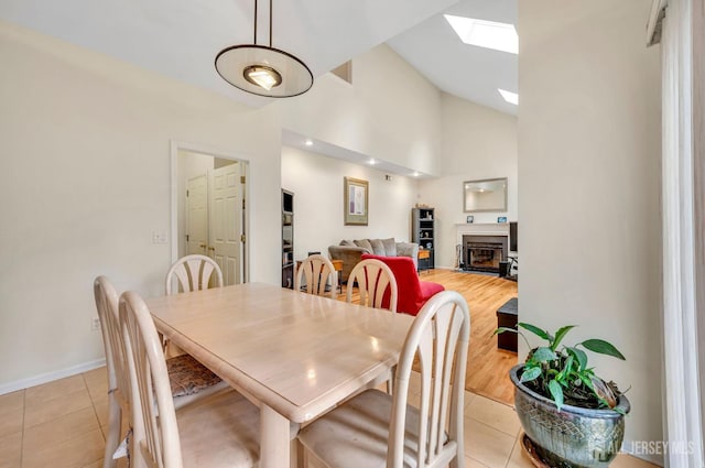 10 Rauer Ct, South Plainfield, NJ 07080 - dining room with light tile patterned flooring, a skylight, a fireplace, and high vaulted ceiling