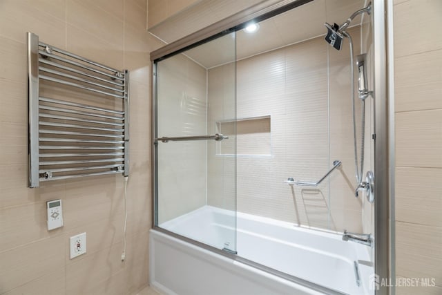 full bathroom featuring radiator and bath / shower combo with glass door